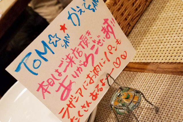 It’s saying “Dear Tom and Kaede! Thank you for your visit xD Please enjoy your dinner xD”